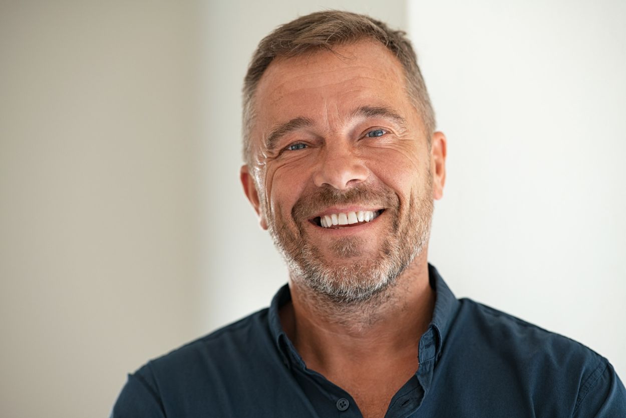 Patient smiling with implant-retained dentures
